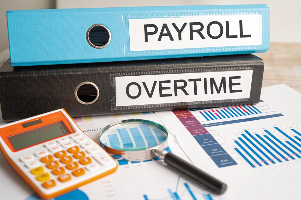 Payroll and Overtime. Binder data finance report business with graph analysis in office.