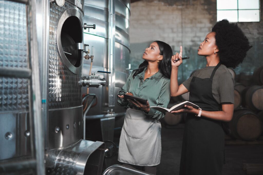 Wine, farming and distillery workers doing quality and sustainability checkup in alcohol manufactur