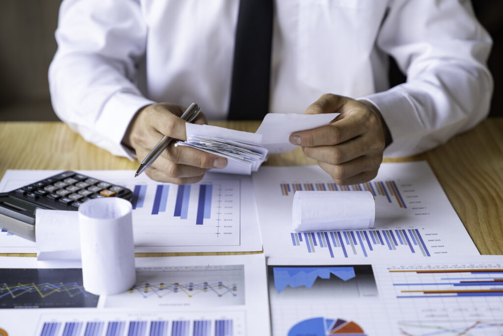 Close-up of businessman's hands collecting bills for tax refund and tax savings, finance banking and