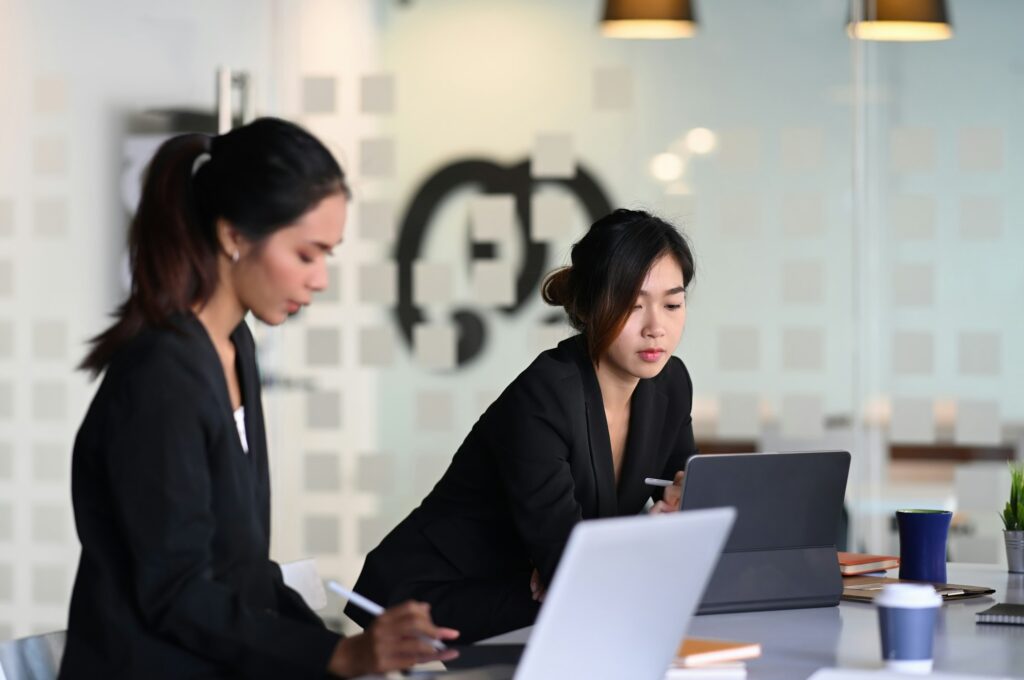 Businesswoman in suit experts discussing information during accounting process in office.